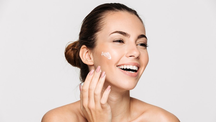 woman applying cream on her skin